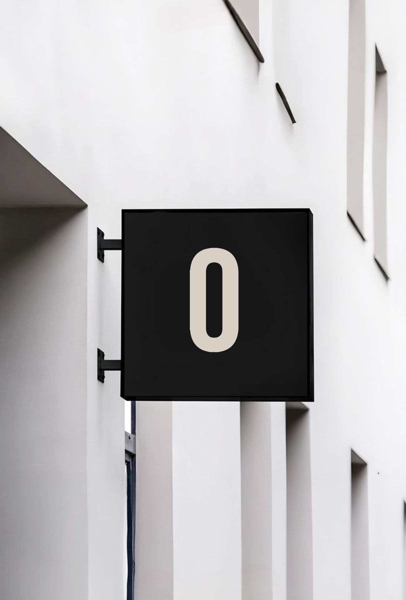 Wall-mounted OUT.LI.ER 'O' signage on a minimalist facade