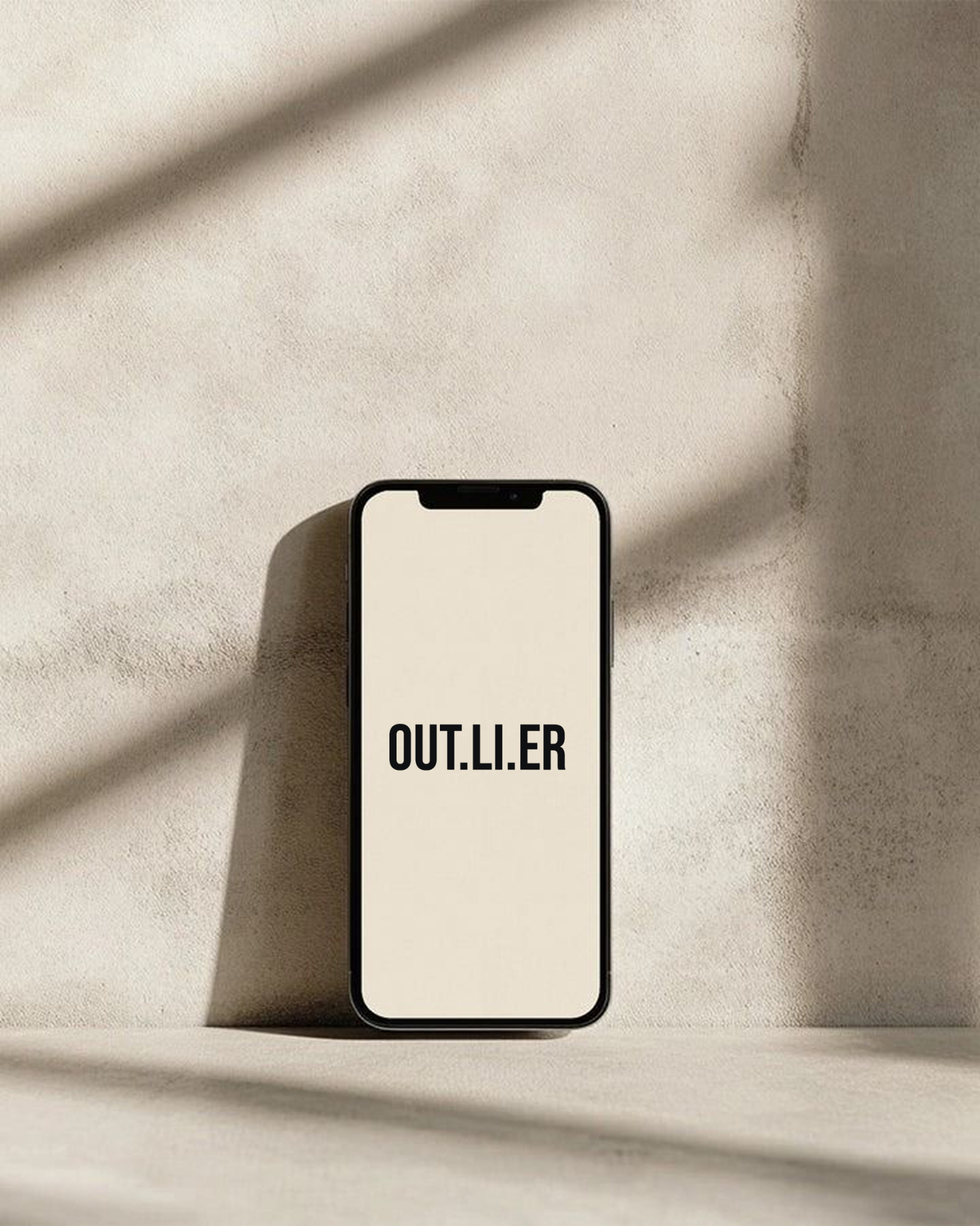 Phone displaying the OUT.LI.ER wordmark on a stone surface